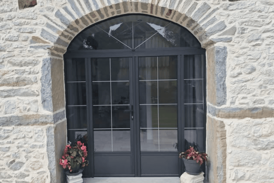 Fourniture et pose d’un ensemble composé d’une porte-fenêtre à 2 battants égaux et 2 fixes latéraux, sous imposte fixe cintrée à oloron